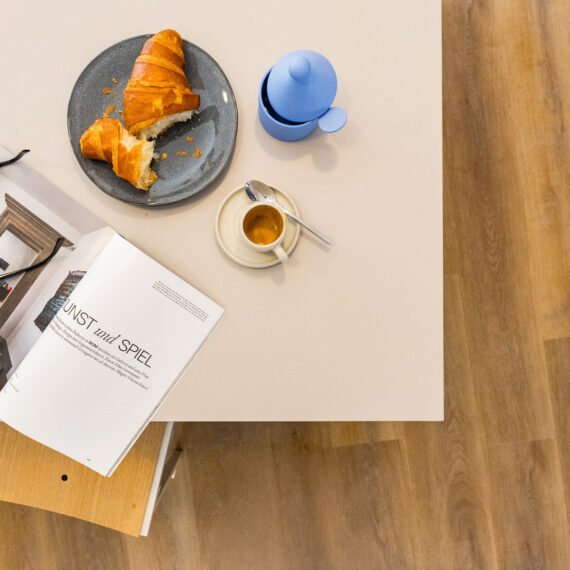 Tisch von oben mit Zeitschrift, Kaffee und Crossaint